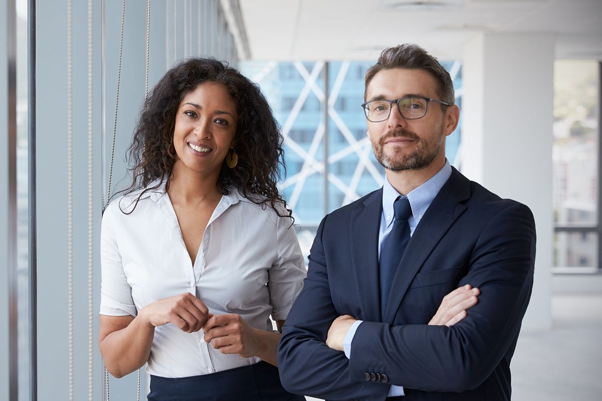Two confident professionals smile after completing a project successfully.