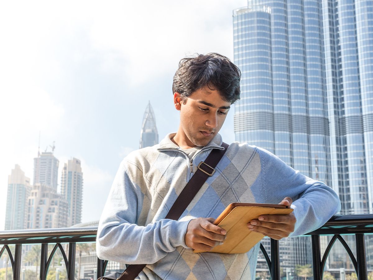 UAE page - resized - young professional on tablet near burj khalifa
